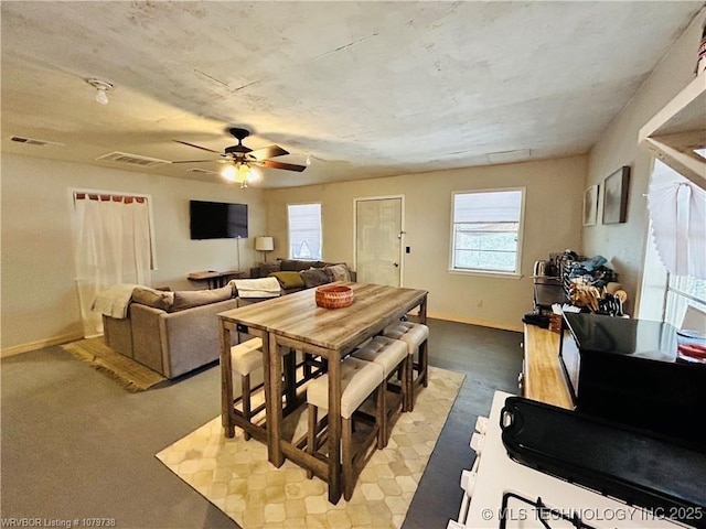dining room with a ceiling fan, visible vents, and baseboards