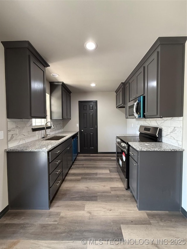 1103 S Chickasaw Pl, Claremore, OK 74017 - kitchen with a sink, decorative backsplash, wood finished floors, and stainless steel appliances