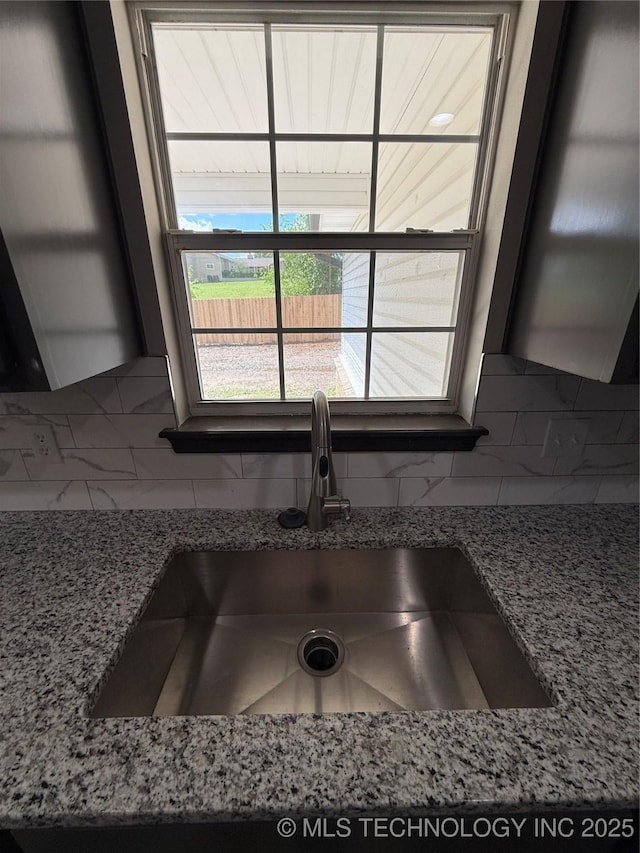 1103 S Chickasaw Pl, Claremore, OK 74017 - interior details featuring light stone countertops, a sink, and tasteful backsplash