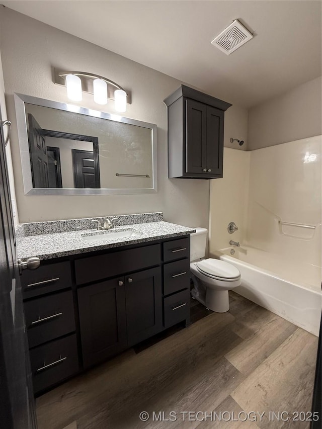 1103 S Chickasaw Pl, Claremore, OK 74017 - full bath featuring visible vents, wood finished floors, vanity, toilet, and  shower combination