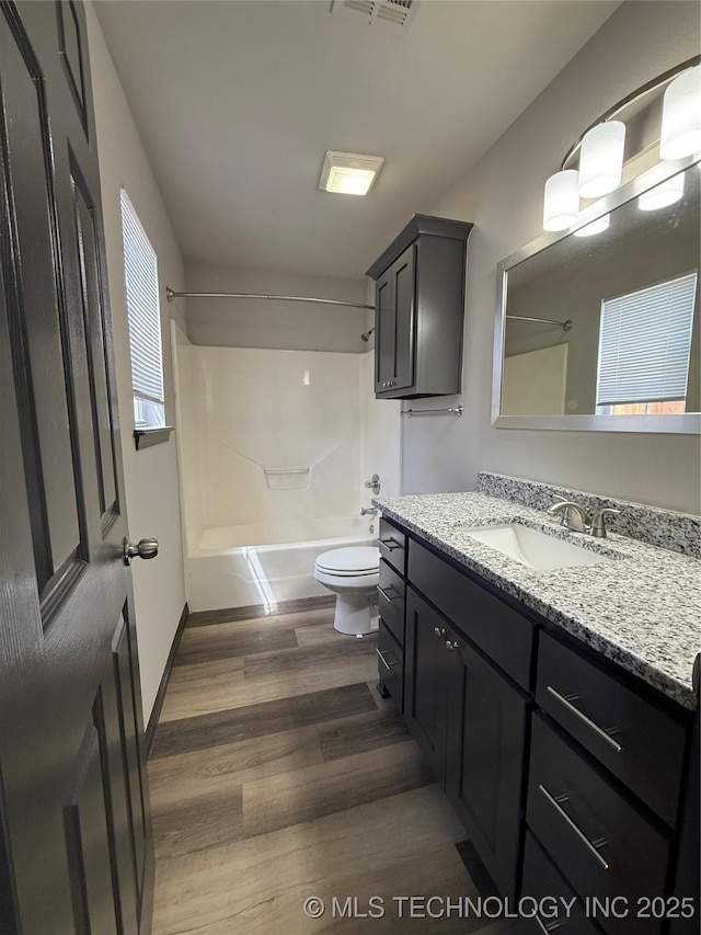 1103 S Chickasaw Pl, Claremore, OK 74017 - bathroom featuring visible vents, wood finished floors, vanity, toilet, and washtub / shower combination