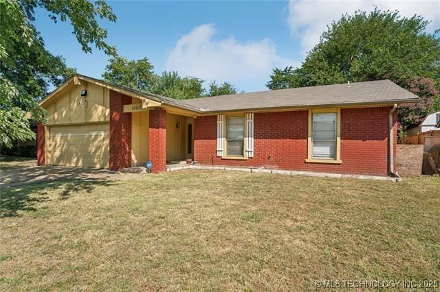 ranch-style home with driveway, a front yard, brick siding, and an attached garage