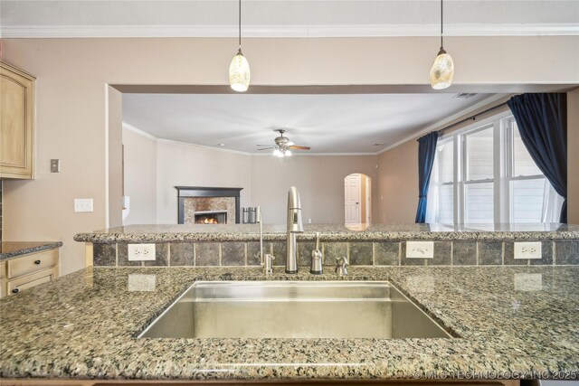 11727 S 91st E Ave, Bixby, OK 74008 - kitchen with a sink, ceiling fan, ornamental molding, a warm lit fireplace, and pendant lighting