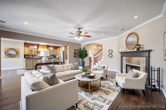 11727 S 91st E Ave, Bixby, OK 74008 - living room with baseboards, a lit fireplace, dark wood-style floors, arched walkways, and recessed lighting