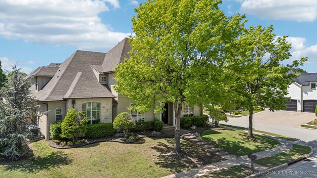 10848 S 95th E Ave, Tulsa, OK 74133 - view of front of home featuring stucco siding, a shingled roof, a front lawn, and stone siding