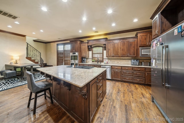 10848 S 95th E Ave, Tulsa, OK 74133 - kitchen featuring a sink, built in appliances, ornamental molding, visible vents, and a kitchen island
