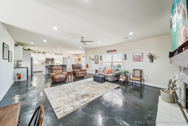 11210 W 178th St, Skiatook, OK 74070 - living area featuring a stone fireplace, finished concrete floors, recessed lighting, and baseboards