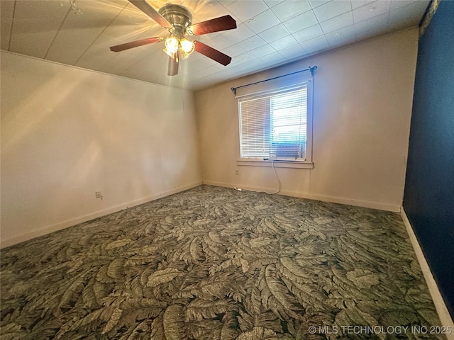 carpeted spare room with a ceiling fan and baseboards