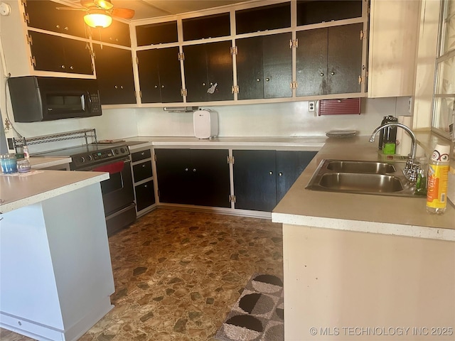 kitchen with stone finish floor, a sink, stainless steel range with electric cooktop, black microwave, and light countertops