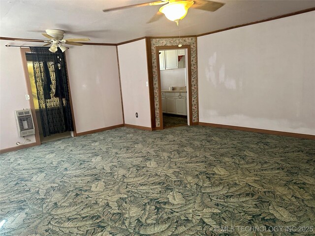 carpeted spare room with baseboards, heating unit, and a ceiling fan