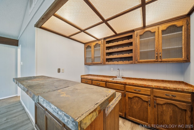6924 S Knoxville Ave, Tulsa, OK 74136 - kitchen featuring light wood finished floors, brown cabinets, glass insert cabinets, and a center island