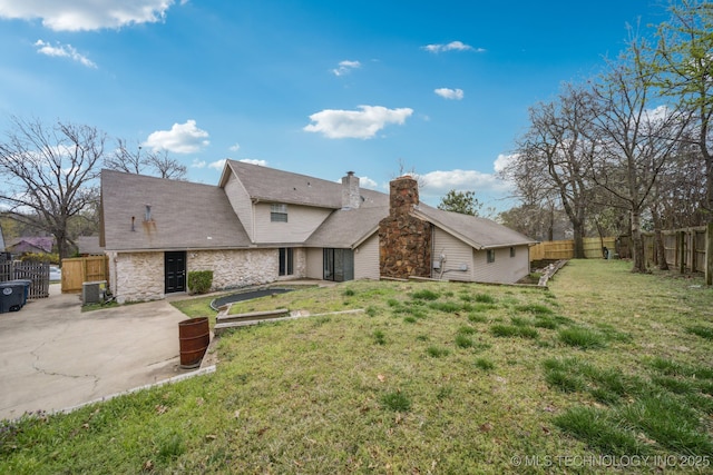 6924 S Knoxville Ave, Tulsa, OK 74136 - view of front of property with stone siding, a fenced backyard, a patio area, and a chimney