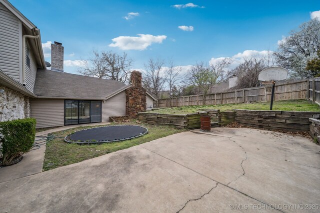 6924 S Knoxville Ave, Tulsa, OK 74136 - fenced backyard with a trampoline and a patio area