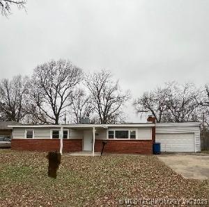 728 S 91st E Ave, Tulsa, OK 74112 - view of front facade featuring a garage, driveway, and brick siding