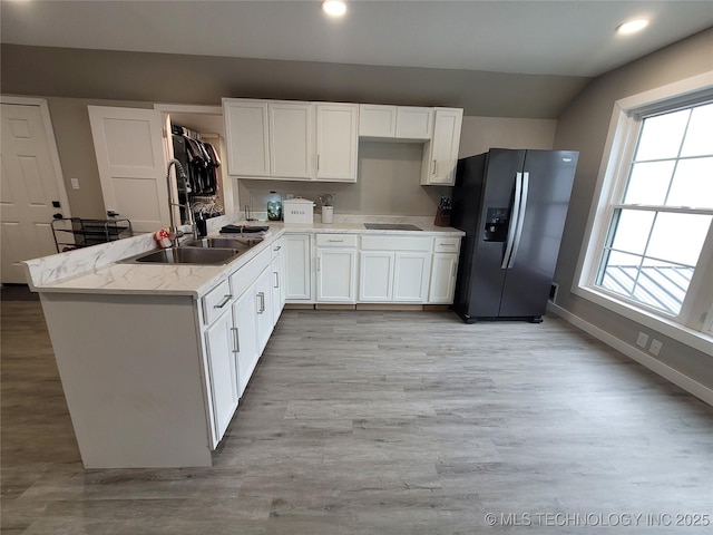 117700 S 4214th Rd, Eufaula, OK 74432 - kitchen featuring fridge with ice dispenser, a sink, vaulted ceiling, light wood-style flooring, and white cabinets