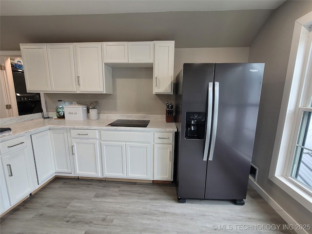 117700 S 4214th Rd, Eufaula, OK 74432 - kitchen with stainless steel fridge, white cabinetry, light wood finished floors, black electric cooktop, and baseboards