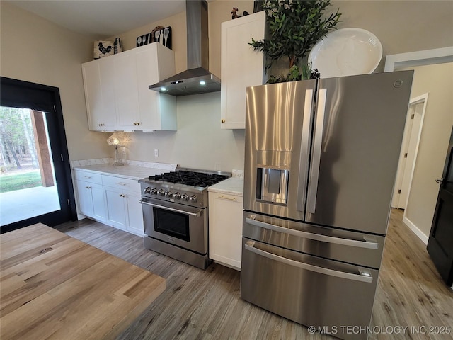 117700 S 4214th Rd, Eufaula, OK 74432 - kitchen featuring stainless steel appliances, wall chimney exhaust hood, light wood-style flooring, light countertops, and white cabinetry