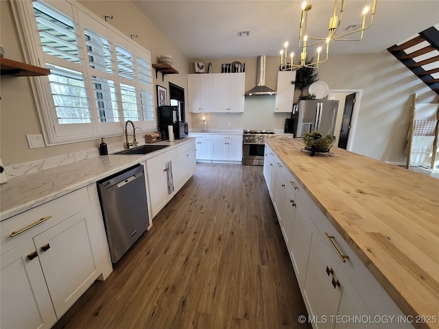 117700 S 4214th Rd, Eufaula, OK 74432 - kitchen with butcher block countertops, appliances with stainless steel finishes, wall chimney range hood, dark wood-type flooring, and a chandelier