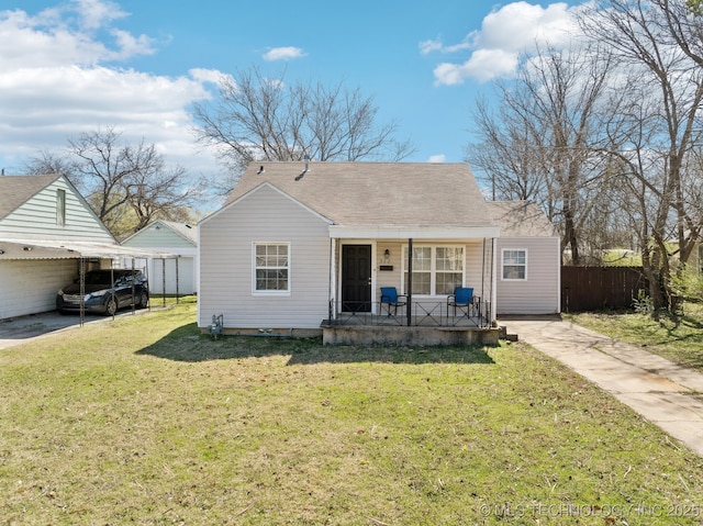 bungalow-style house with a front yard, fence, a porch, concrete driveway, and a carport