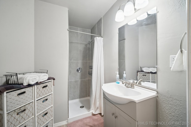 bathroom with a shower stall and vanity