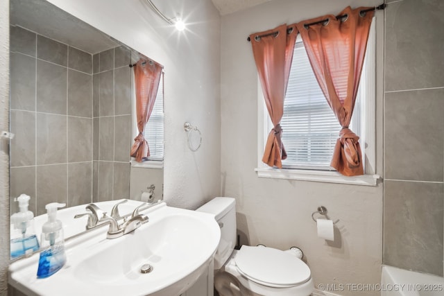 full bathroom with a bathtub, toilet, and a sink
