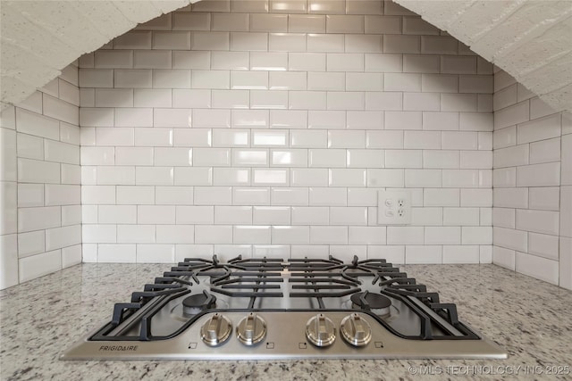 details with light stone countertops and stainless steel gas cooktop