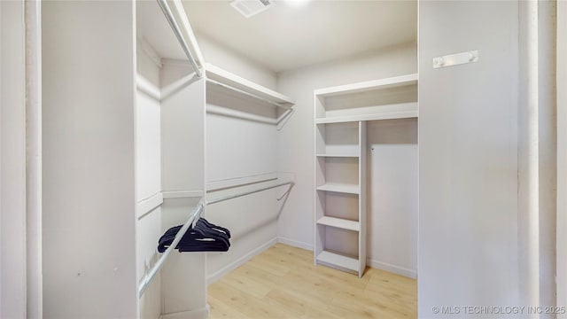 walk in closet featuring visible vents and wood finished floors