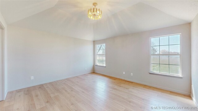 11762 N 156th E Ave, Collinsville, OK 74021 - empty room with lofted ceiling, a chandelier, light wood-style floors, and baseboards