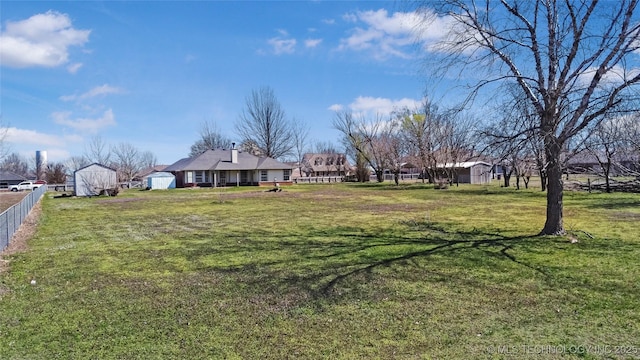 view of yard featuring a shed, an outdoor structure, and fence