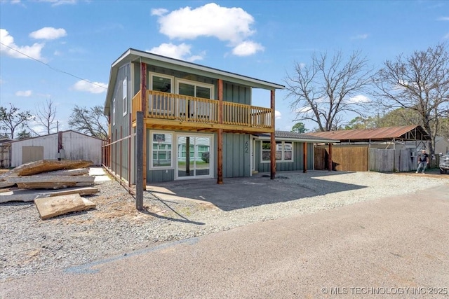 62 Jolene Reid Rd, Mead, OK 73449 - back of house with board and batten siding, driveway, and an outdoor structure
