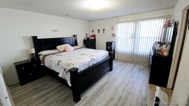 bedroom featuring a textured ceiling and light wood-style floors