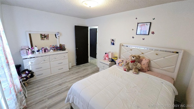 bedroom featuring a textured ceiling and light wood finished floors