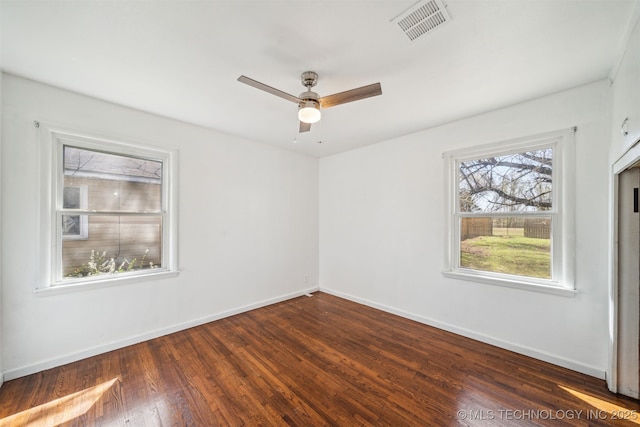 unfurnished room with visible vents, dark wood-type flooring, and baseboards