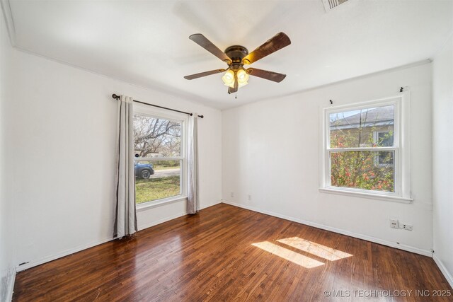 empty room featuring wood finished floors, baseboards, and ceiling fan