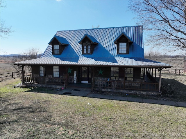 farmhouse featuring metal roof, covered porch, and a front yard