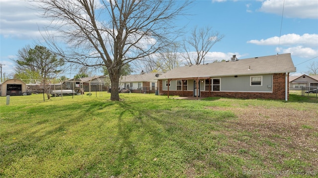 313 S Fairfax Ave, Skiatook, OK 74070 - back of property featuring a yard, brick siding, and fence