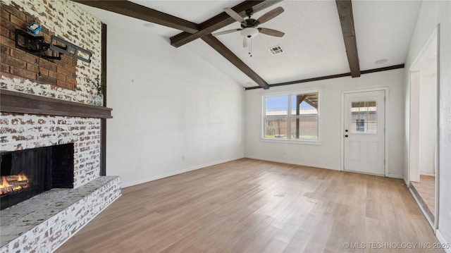 313 S Fairfax Ave, Skiatook, OK 74070 - unfurnished living room featuring a fireplace, visible vents, vaulted ceiling with beams, and light wood-type flooring
