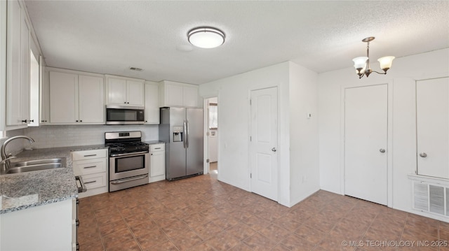 313 S Fairfax Ave, Skiatook, OK 74070 - kitchen featuring visible vents, a sink, a chandelier, and appliances with stainless steel finishes