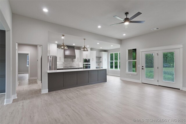 3995 Folsom Rd, Durant, OK 74701 - kitchen featuring appliances with stainless steel finishes, light countertops, custom exhaust hood, white cabinetry, and baseboards