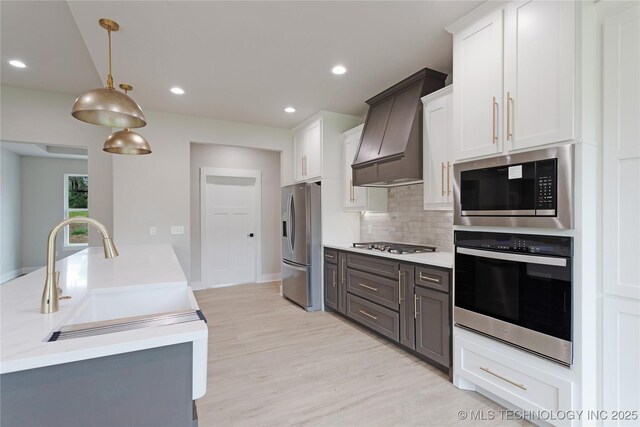 3995 Folsom Rd, Durant, OK 74701 - kitchen featuring appliances with stainless steel finishes, premium range hood, light countertops, a sink, and recessed lighting