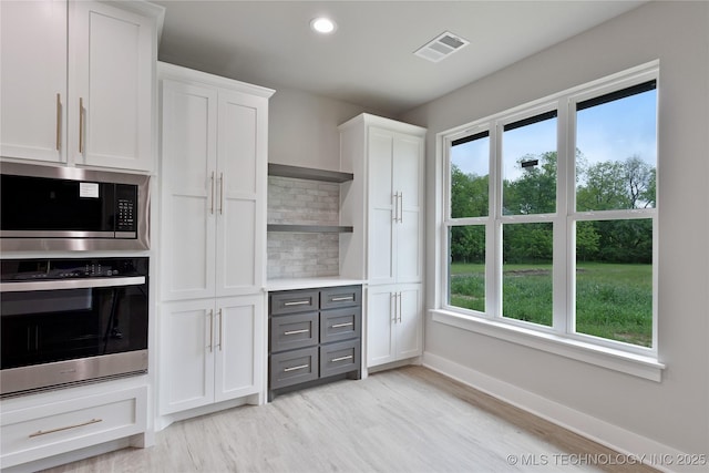 3995 Folsom Rd, Durant, OK 74701 - kitchen with stainless steel appliances, open shelves, tasteful backsplash, white cabinets, and plenty of natural light