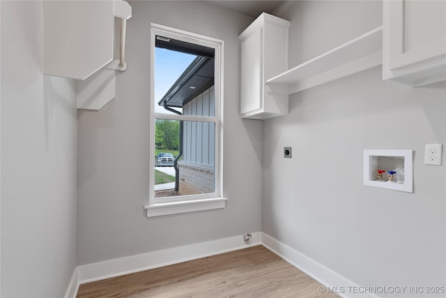 3995 Folsom Rd, Durant, OK 74701 - laundry room with electric dryer hookup, cabinet space, washer hookup, wood finished floors, and baseboards