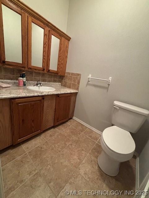 142 Elm St, Mannford, OK 74044 - bathroom with toilet, vanity, backsplash, and baseboards