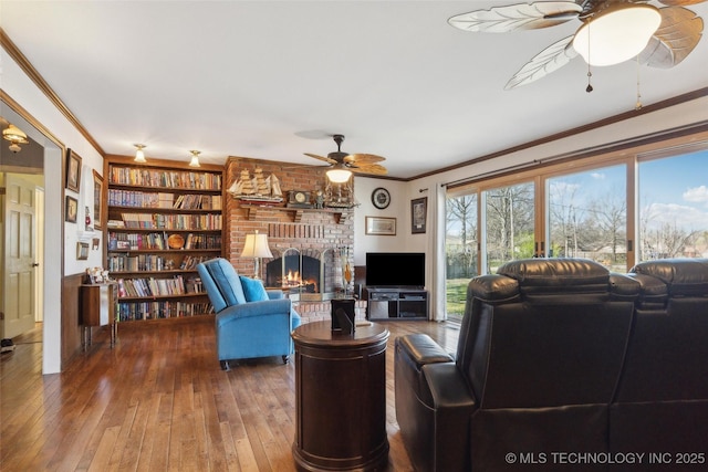 108 S Bettes Ave, Wagoner, OK 74467 - living area with ornamental molding, built in shelves, hardwood / wood-style flooring, ceiling fan, and a brick fireplace