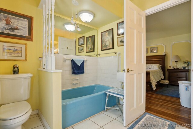 108 S Bettes Ave, Wagoner, OK 74467 - bathroom with toilet, tile patterned floors, ensuite bathroom, and a bath