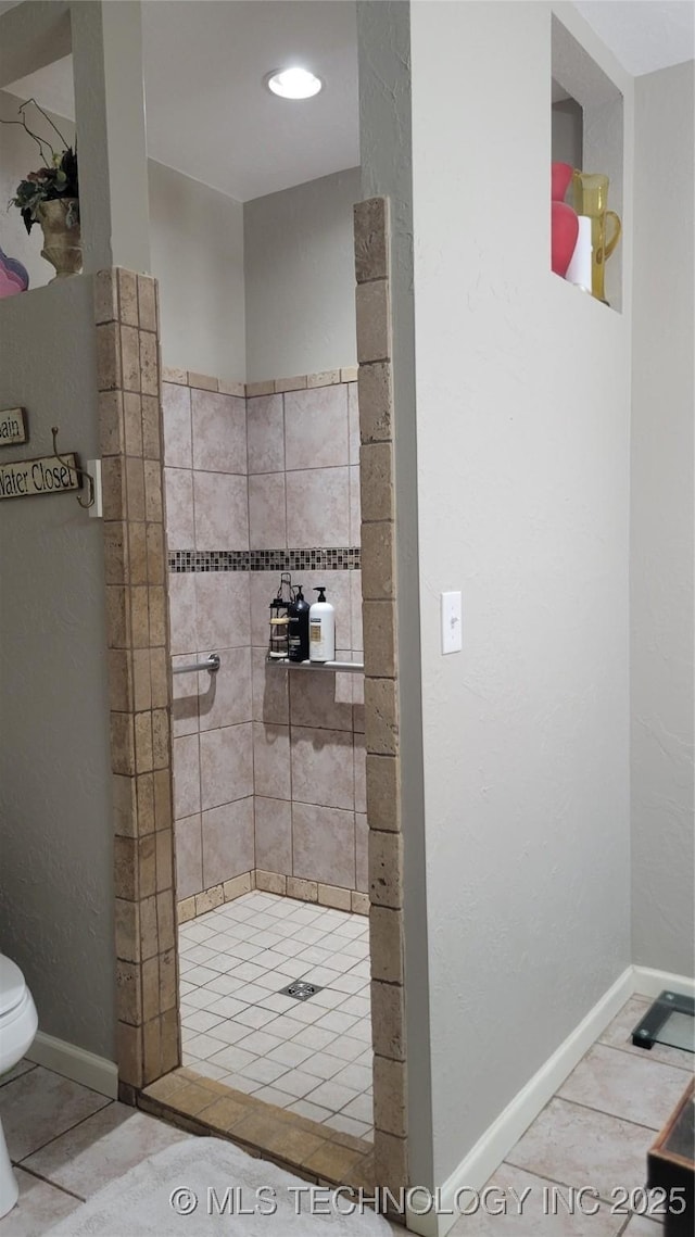 6111 County Road 3605, Ada, OK 74820 - bathroom featuring toilet, tile patterned floors, baseboards, and a tile shower