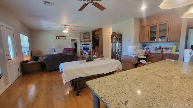 6111 County Road 3605, Ada, OK 74820 - kitchen with light wood-type flooring, visible vents, brown cabinetry, and a ceiling fan