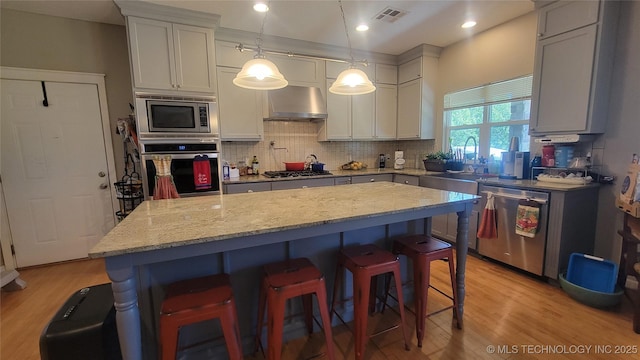 6111 County Road 3605, Ada, OK 74820 - kitchen featuring visible vents, wall chimney exhaust hood, stainless steel appliances, tasteful backsplash, and a sink