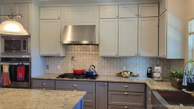 6111 County Road 3605, Ada, OK 74820 - kitchen with light stone countertops, stainless steel appliances, gray cabinetry, wall chimney range hood, and backsplash