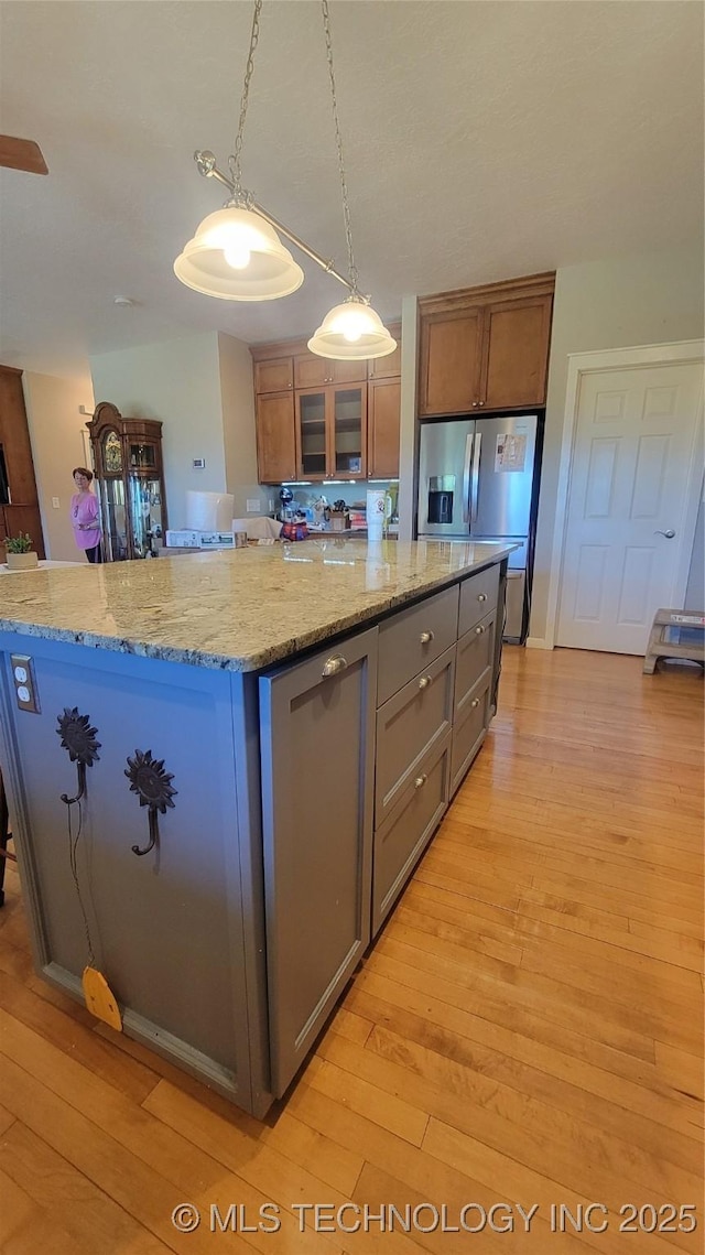 6111 County Road 3605, Ada, OK 74820 - kitchen with light wood finished floors, stainless steel appliances, glass insert cabinets, pendant lighting, and a center island